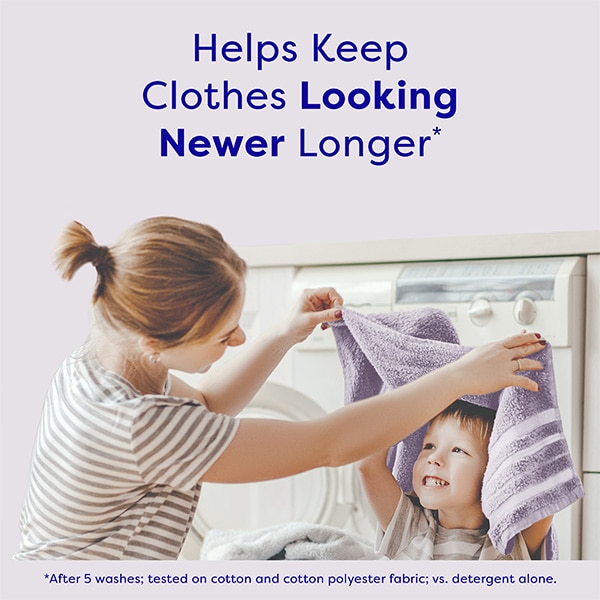Mother drying child's face with a towel in laundry room, with text highlighting that fabric softener helps keep clothes looking newer longer. Mother drying child's face with a towel in laundry room, with text highlighting that fabric softener helps keep clothes looking newer longer.